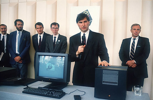 Man standing talking in front of a computer