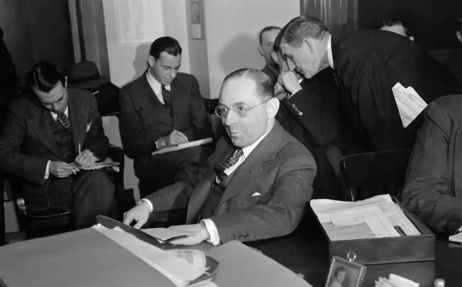 black and white photo of men in a room sitting at desks