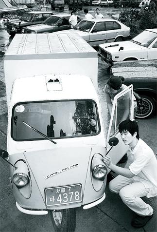 black and white photos of man working on a car