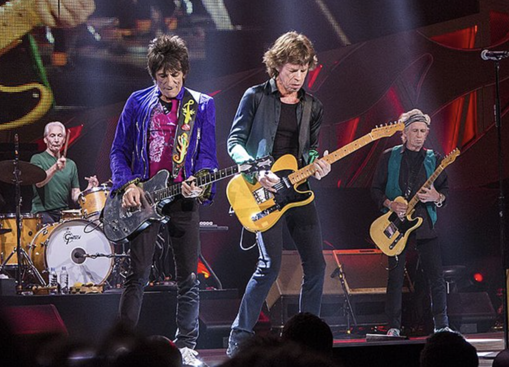 Men playing guitars on a stage