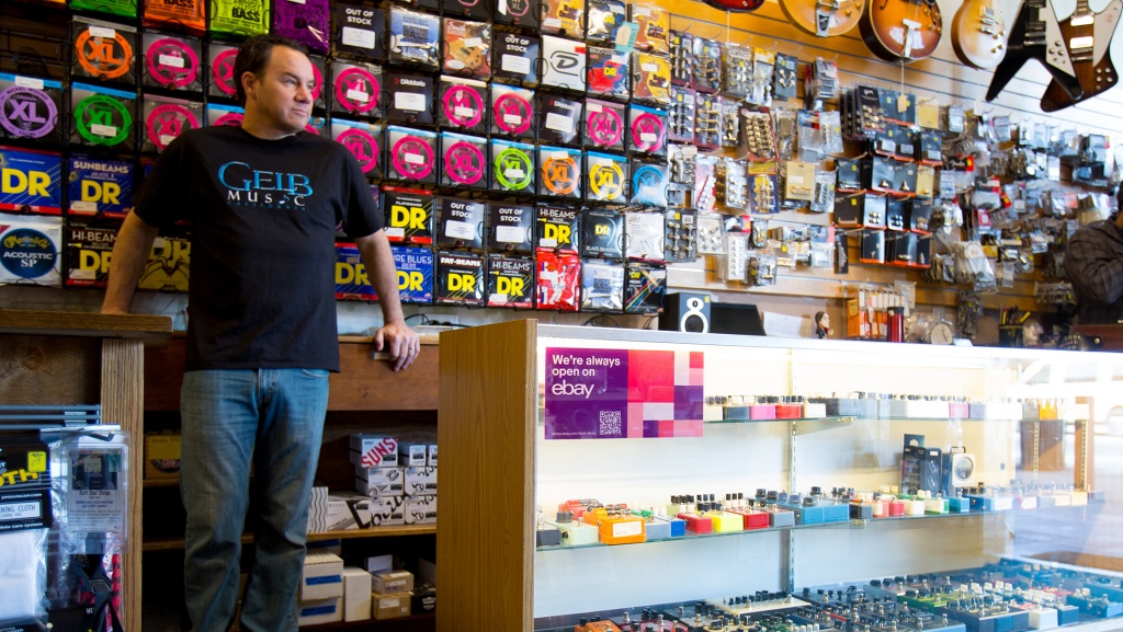 man in store leaning against counter