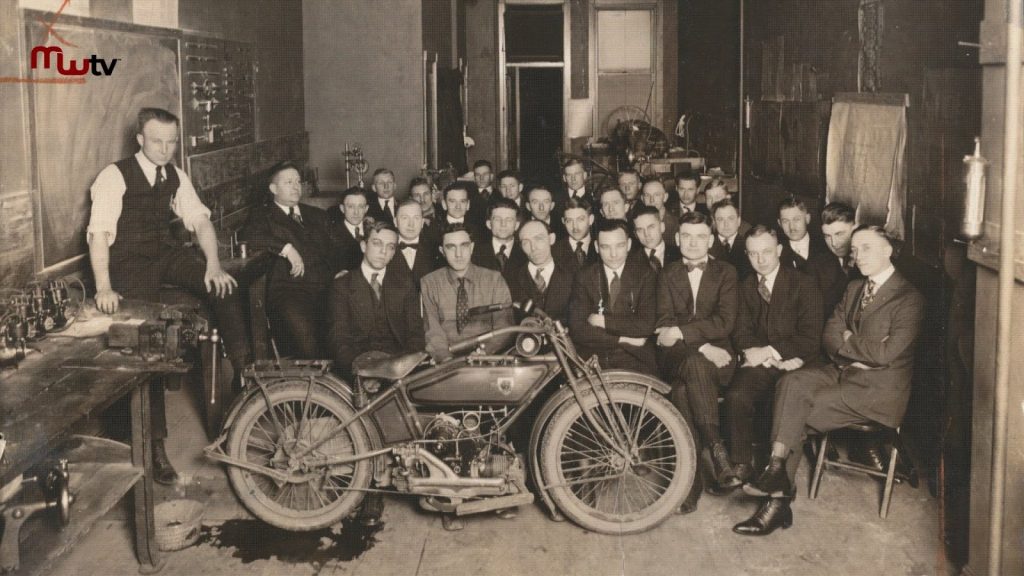 vintage photo of men sitting in front of a motorcyle